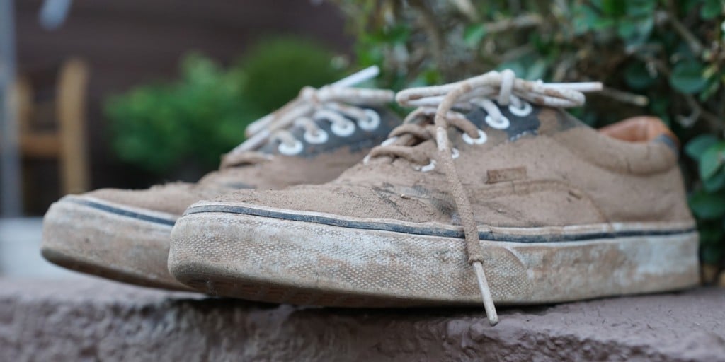 Pulizia delle scarpe bianche cura delle scarpe da ginnastica una donna  pulisce le scarpe in pelle con un panno umido da polvere e sporco