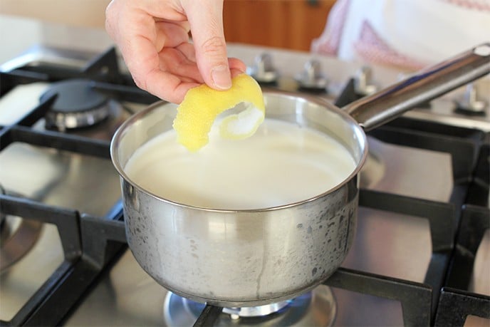 Iniziamo versando il latte in una pentola, aggiungiamo la scorza di limone e lasciamolo riscaldare bene sul fuoco. 
