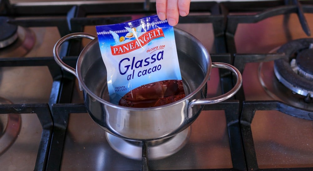 Quando bolle, spengiamo il fuoco e mettiamo la confezione di Glassa al cacao PANEANGELI nell'acqua bollente per 7-8 minuti.