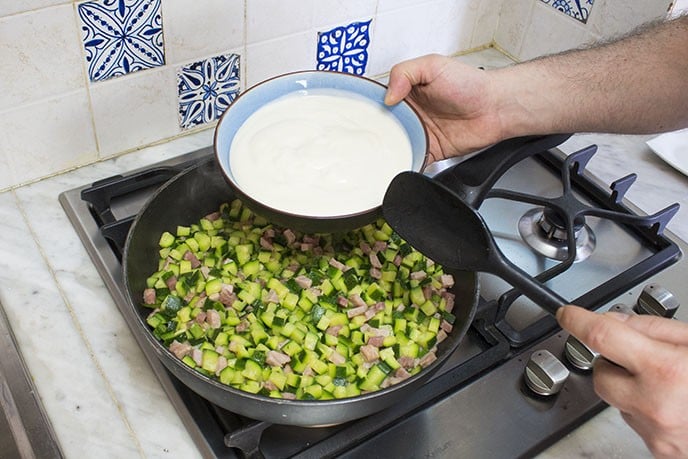 Cotte le zucchine, spegnete il fuoco e aggiungete la besciamella. Mescolate per bene tutti gli ingredienti fino a distribuirli uniformemente nella besciamella.