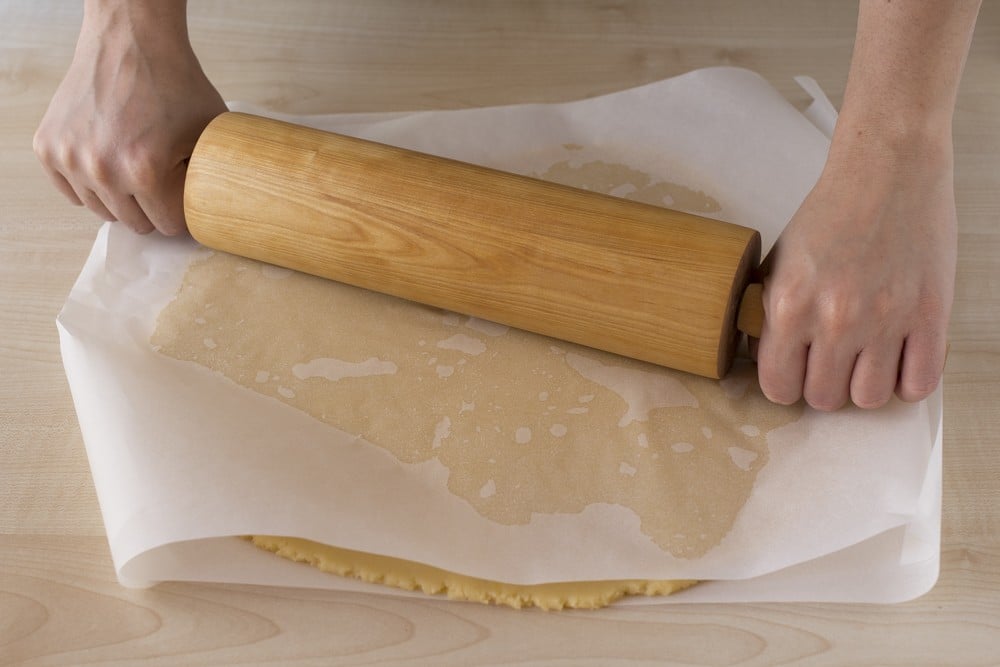 Stendete il panetto ottenuto direttamente sulla spianatoia aiutandovi con un pochino di farina o stendetelo tra 2 fogli di carta forno, aiutandovi con un matterello.