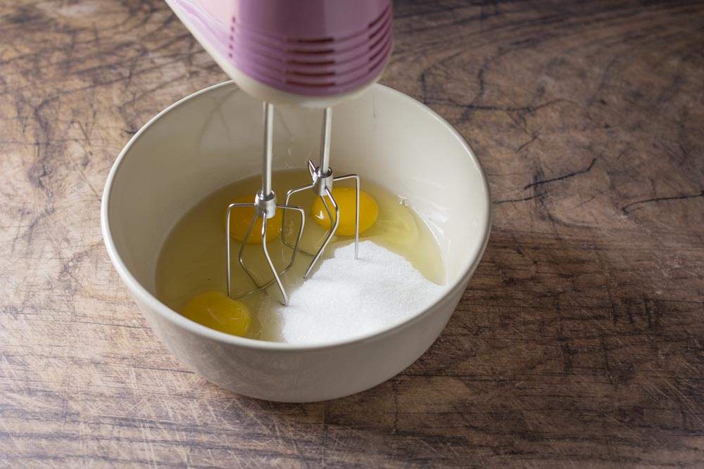 In una ciotola inserite le 3 uova intere, lo zucchero e montate con le fruste elettriche, per almeno 5 minuti o fino ad ottenere un composto chiaro e spumoso.