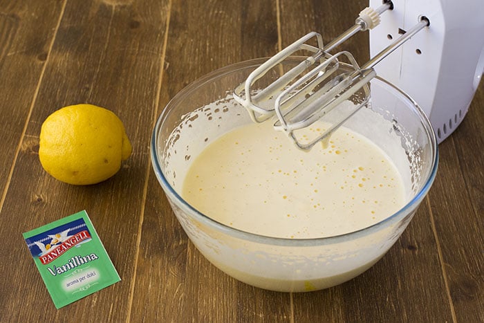 Aggiungete adesso al composto le aromatizzazioni, quindi la Vanillina PANEANGELI e la scorza di limone grattugiata, e mescolate di nuovo fino a farle ben integrare all'impasto.