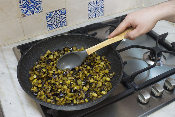 Riscaldate un filo d'olio d'oliva in una padella capiente, quindi mettete le melanzane tagliate a cubetti piccoli e salatele secondo i vostri gusti. Saltate le melanzane a fiamma vivace per una decina di minuti, rigirandole con frequenza; le melanzane in questo modo avranno una cottura a metà strada fra il grigliato e il fritto. Cotte le melanzane, mettetele un attimo da parte e dedicatevi alla cottura del riso.  