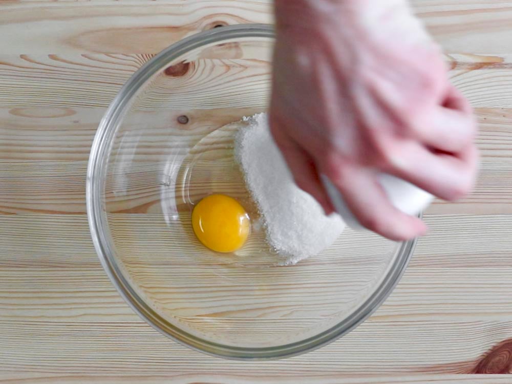 In una ciotola rompiamo l’uovo e lo mescoliamo con lo zucchero.