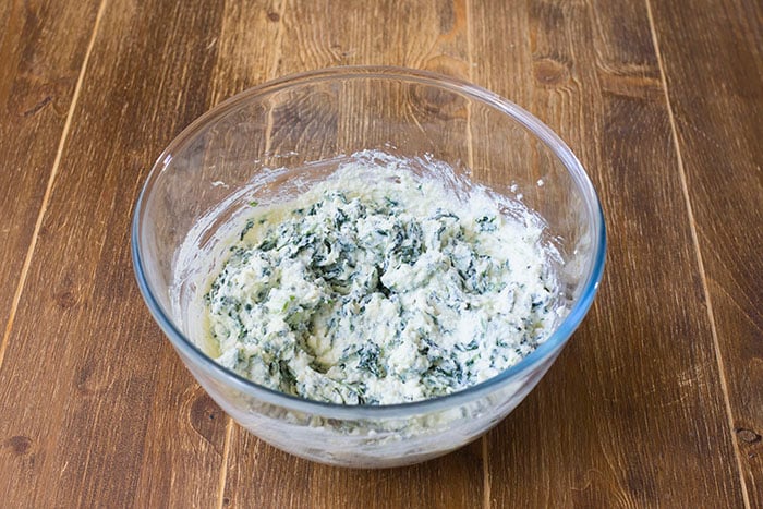 In una ciotola capiente mischiamo la ricotta ben sgocciolata insieme agli spinaci e al formaggio grattugiato. Ottenuto un composto omogeneo, il ripieno della focaccia è pronto! 
