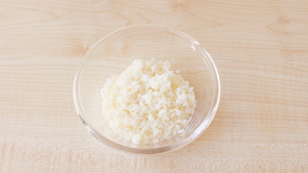 Prepariamo il riso, facciamo cuocere il riso originario in abbondante acqua non salata finché non sarà ben cotto, poi scoliamolo sotto l'acqua fredda e mettiamolo da parte.