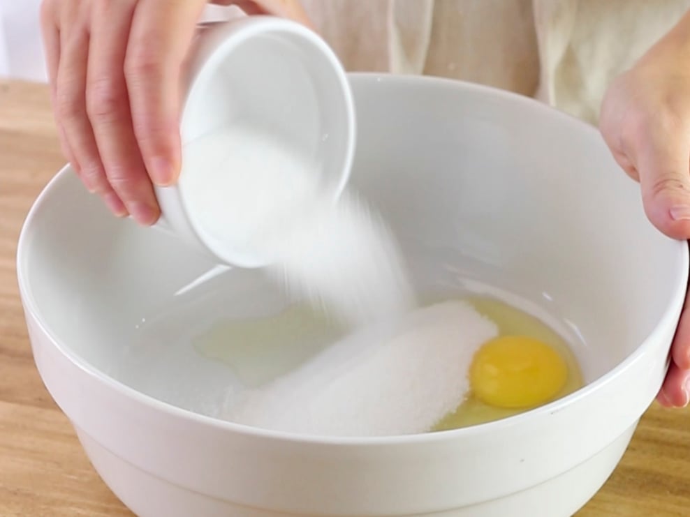 In una ciotola rompiamo l'uovo e aggiungiamo lo zucchero.