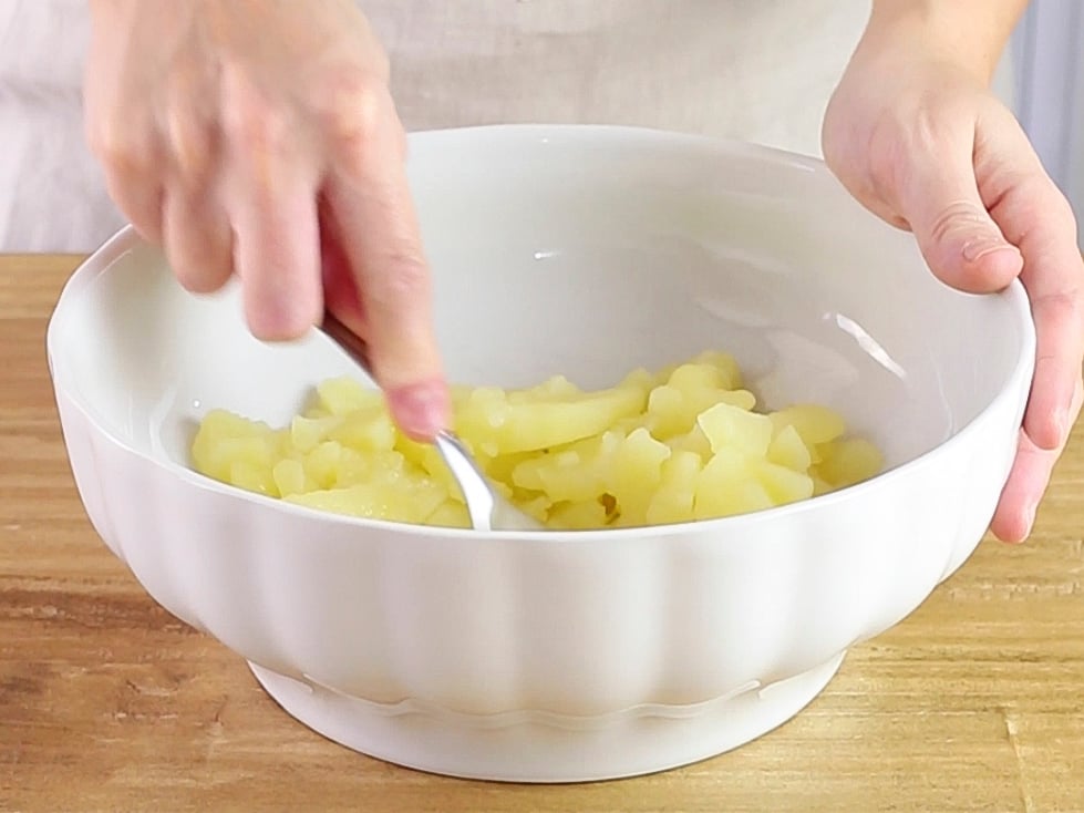 In una ciotola schiacciamo le patate lesse con una forchetta o uno schiaccia patate.