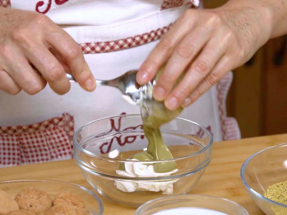 Mescoliamo in una ciotolina il formaggio spalmabile e la crema di pistacchio. 