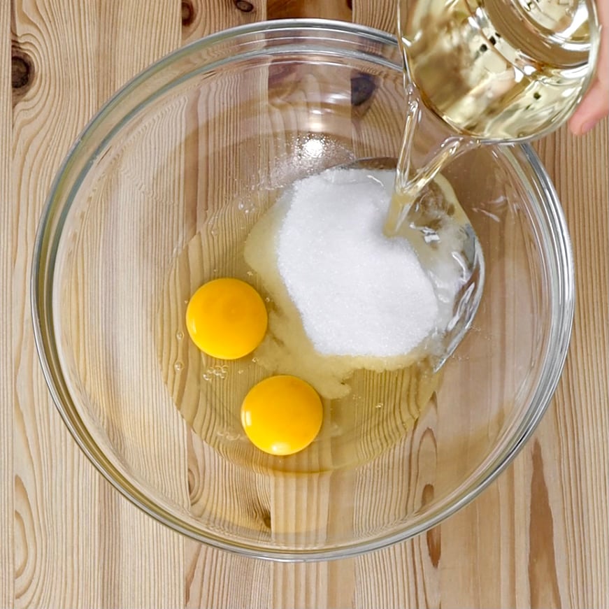 Prepariamo la pasta frolla: in una ciotola mescoliamo le uova, lo zucchero e l’olio con un cucchiaio fino a ottenere un composto omogeneo.