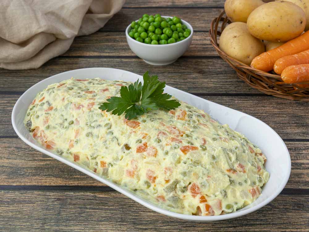 Trascorso il tempo, la nostra insalata russa furba è pronta. Sistemiamola in un bel piatto da portata e decoriamo con un ciuffetto di prezzemolo!