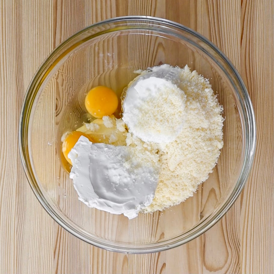 In una ciotola mescoliamo la ricotta, il formaggio grattugiato e le uova per ottenere una crema liscia.